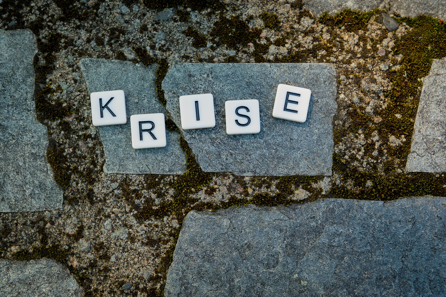 scrabblebrikker på en stein der det står KRISE