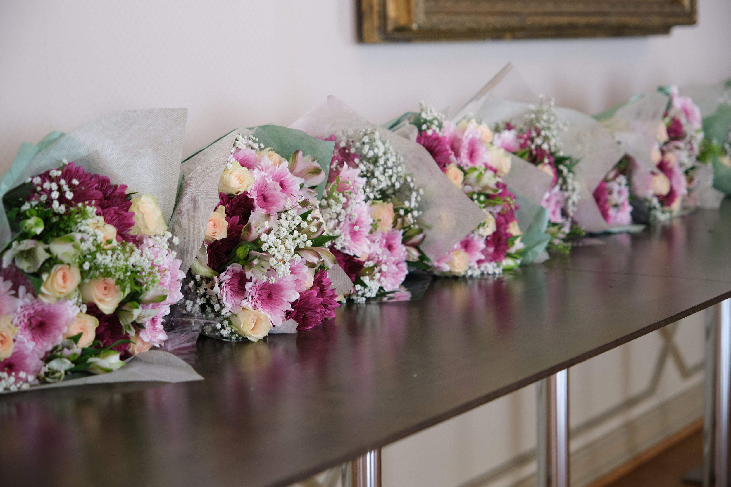 en bord med rosa blomsterbuketter liggende på et bord