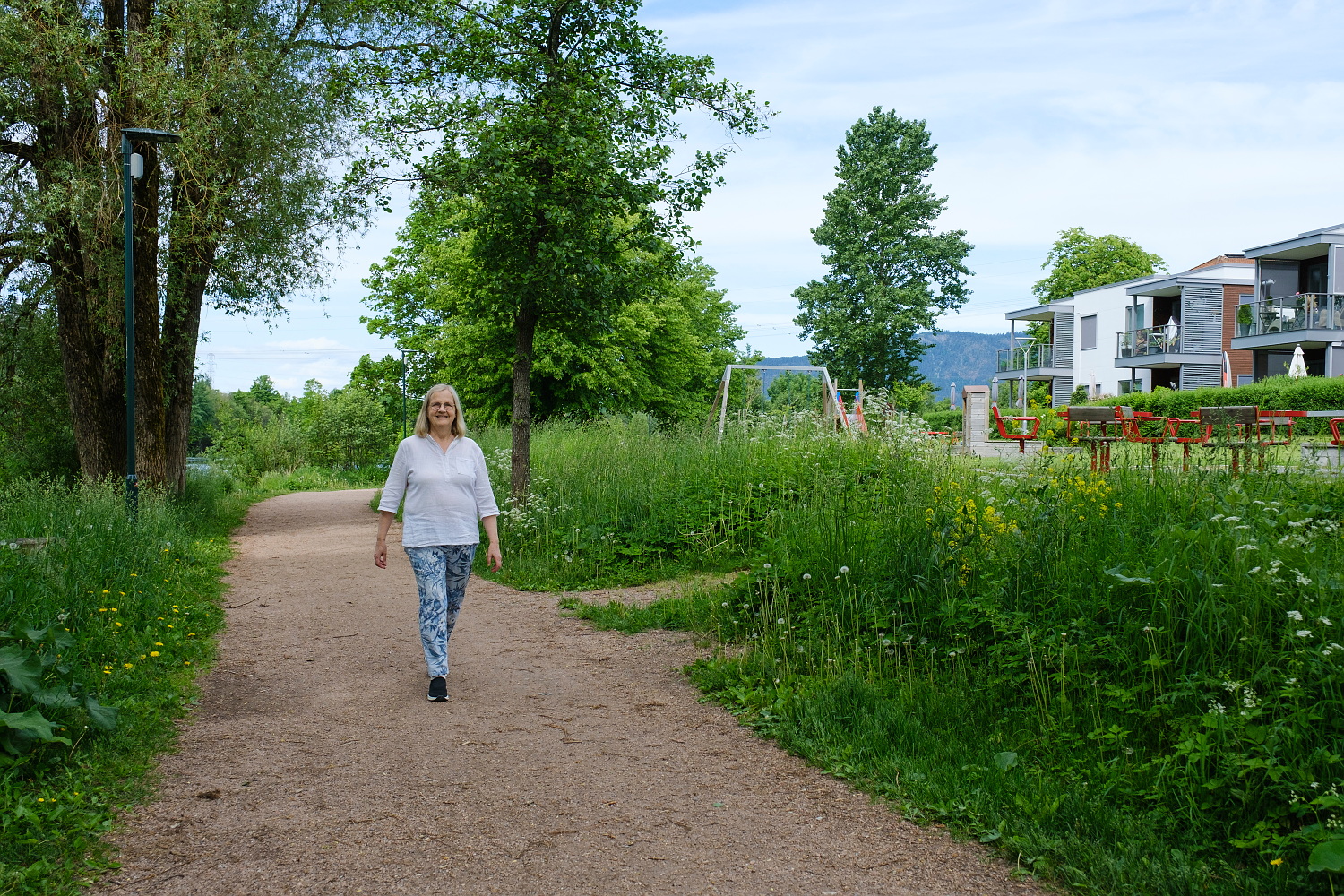 Elbjørg kommer gående mot oss på en grussti langs elva.