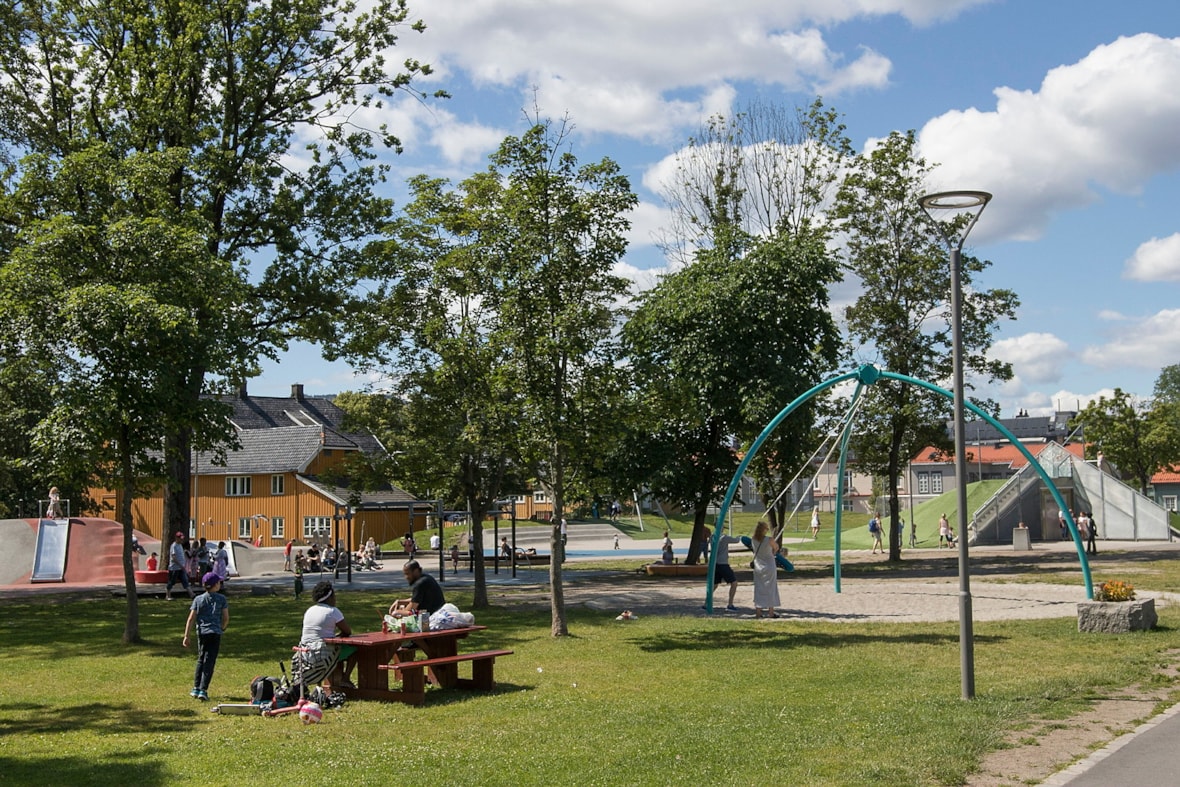 Drammen park med benker, huskestativ og sklie.