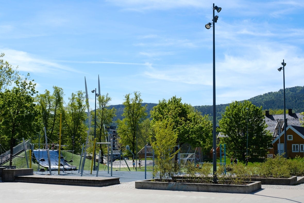 Drammen park med lekeapparater, slier og treningsapparater.
